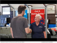 American Freight store associate greeting a customer.