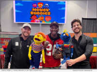 Co-creators Samuel Howe (L) and Travis Grenier (R) pose with Share the Magic's Malcolm Mitchell at an event at Hebron Christian Academy.